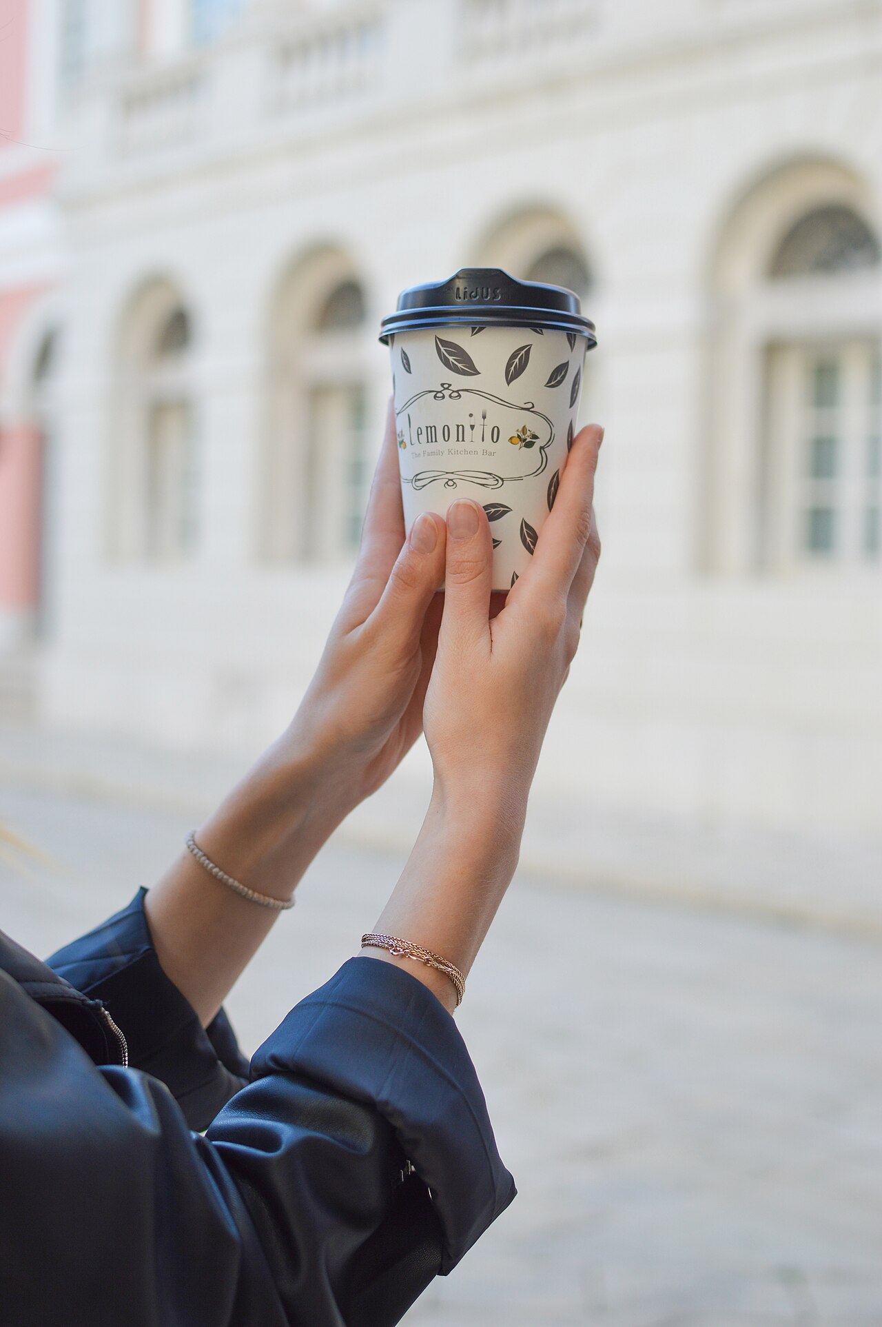 Paper coffee cup held in two hands, the format used by the Half Full charity campaign in Ukraine